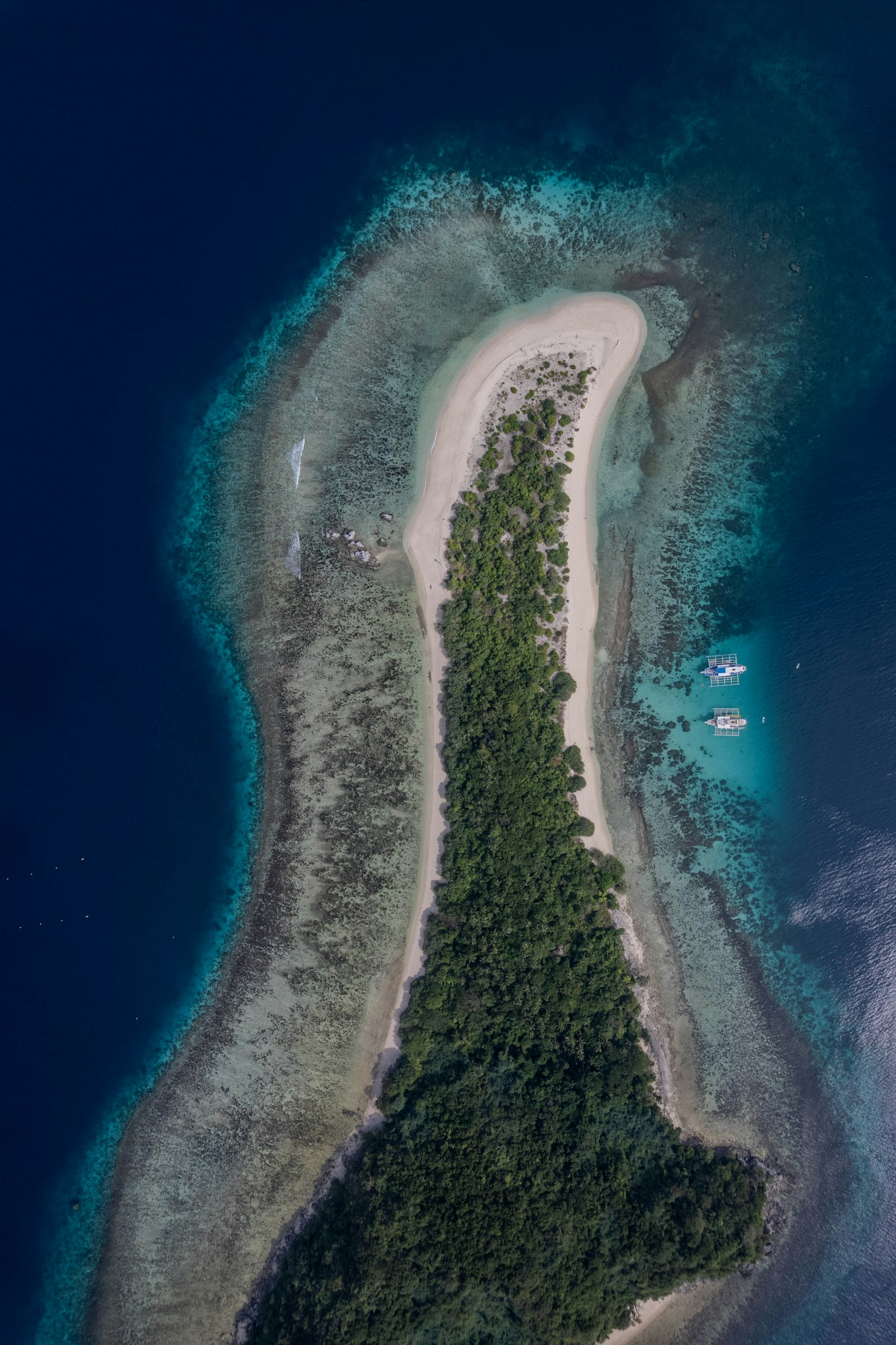 A turquoise lagoon ringed by tropical forest and white sand